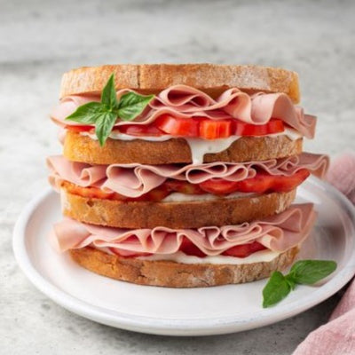 Three layer white bread sandwich filled with  Mortadella, Paisa White Cheese and Tomatos.