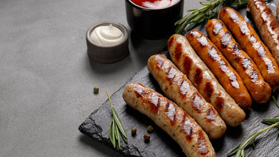 7 perfectly grilled colombian chorizos presented on a dark grey wooden cutting board