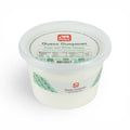 A plastic tub of Queso Guayanes fresh soft white cheese from the brand El Tuck, featuring a white label with green mosaic accents and a clear lid, set against a plain white background.