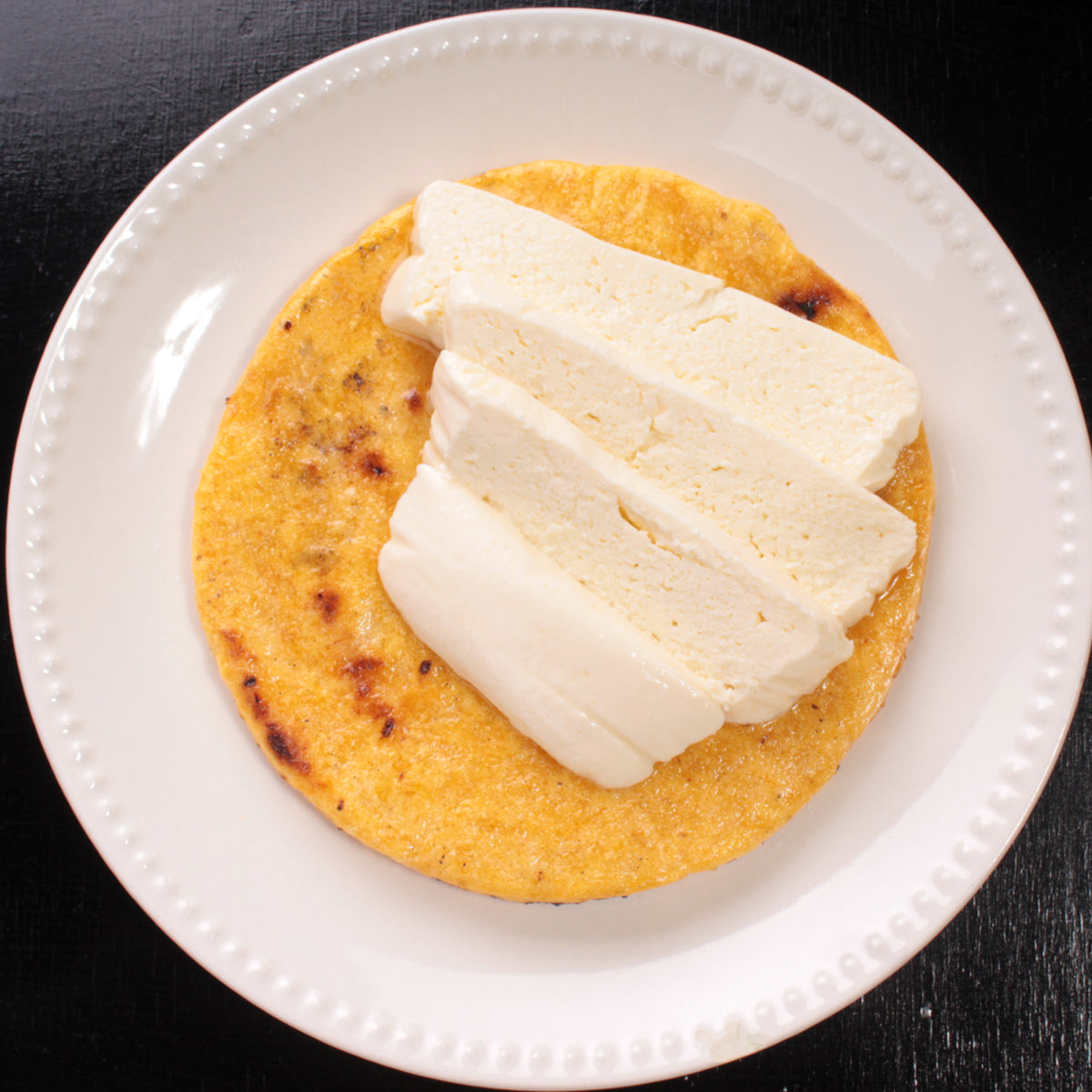 Yellow Corn Colombian Arepa topped with 4 pieces of Paisa White Chees