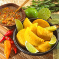 Colombian Style Empanadas served in a black bowl with zesty lemon and pepper sauce, a mouthwatering South American appetizer.
