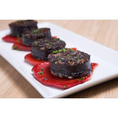 Traditional Colombian Morcilla sausage served on a bed of red peppers, a flavorful and cultural delicacy